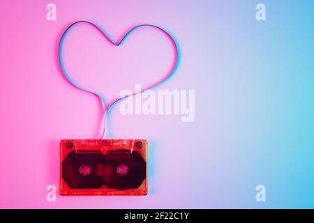 Retro cassette on colorful background with magnetic tape in shape of heart. Love music concept Stock Photo