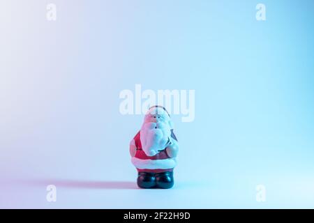 Small Santa Claus in vibrant bold gradient holographic colors. Christmas and New Year minimal art concept. Stock Photo