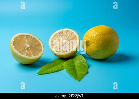Fresh sliced lemon on blue background. Minimal food concept. Stock Photo