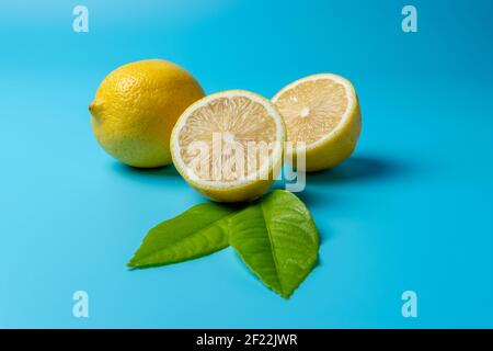Fresh sliced lemon on blue background. Minimal food concept. Stock Photo
