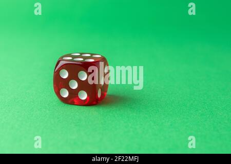 Red playing dice on green table. Luck and fortune concept. Stock Photo