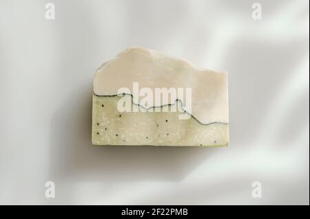 Handmade soap and sunshade shadow on white background. Zero waste, eco friendly cosmetics concept. Vintage color filter Stock Photo
