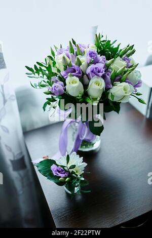 Beautiful delicate bridal bouquet white and purple on the table, floral wedding theme. Stock Photo