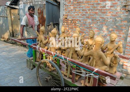 Lumding, India - January 2021: A potter craftsman transporting sculptures in a wheelbarrow on January 16, 2021 in Lumding, Assam, India. Stock Photo