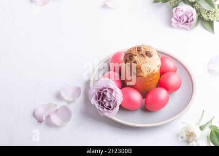 Mini panettone, natural dyed pink eggs and flowers on festive table, Easter brunch, holiday  celebration Stock Photo