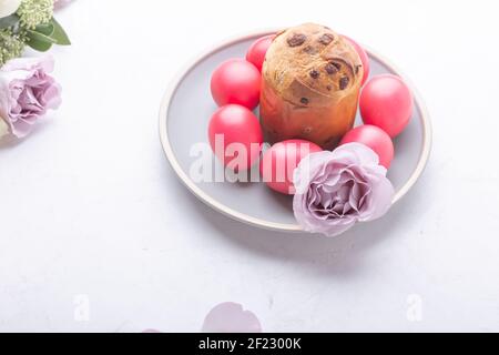 Mini panettone, natural dyed pink eggs and flowers on festive table, Easter brunch, holiday  celebration Stock Photo