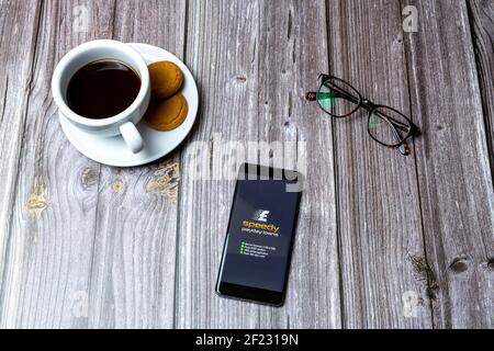 A Mobile phone or cell phone laid on a wooden table with the Speedy payday loans app open on screen Stock Photo