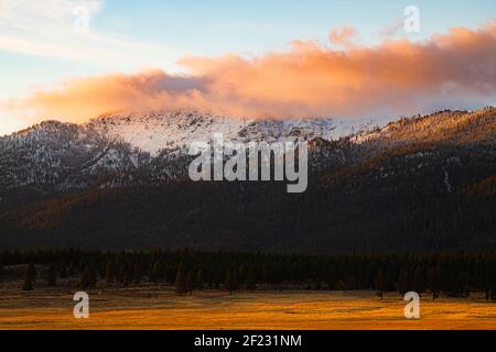 Thompson Peak in Northern California, USA, featuring moody clouds and fresh snow after a storm in early morning light. Stock Photo