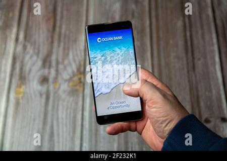03-10-2021 Portsmouth, Hampshire, UK A Mobile phone or cell phone being held in a hand with the Ocean Bank app open on screen Stock Photo