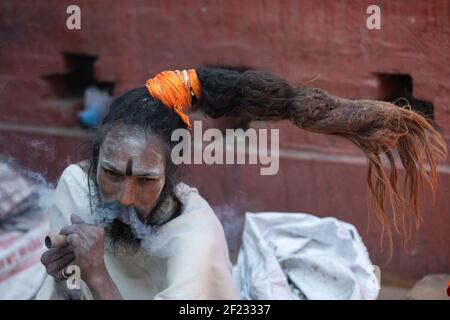 Kathmandu, Nepal. 10th Mar, 2021. A Hindu holy man, or sadhu, smokes marijuana at the Pashupatinath Temple ahead of the Shivaratri festival in Kathmandu.Hindu Devotees from Nepal and India come to this temple to take part in the Shivaratri festival which is one of the biggest Hindu festivals dedicated to Lord Shiva and celebrated by devotees all over the world. Credit: SOPA Images Limited/Alamy Live News Stock Photo