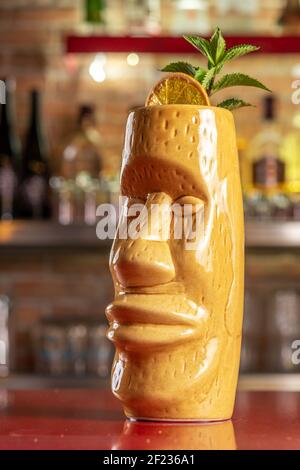 Refreshing cold Tiki cocktail on the bar. Summer party background. Stock Photo