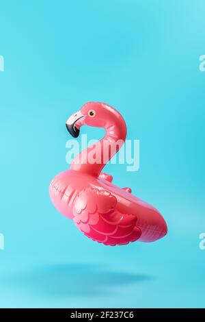 Inflatable pool toy flamingo on a blue background. Minimal summer concept. Stock Photo
