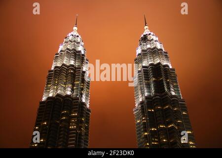 Close up shot of the Petronas Twin Towers at night with illuminated orange cloud Stock Photo