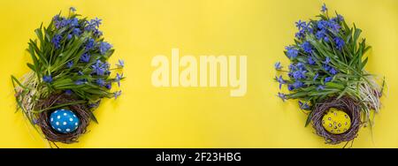 Easter background. Easter flowers. Easter eggs. Happy Easter card. Multi-colored Easter eggs. Banner. Yellow background Stock Photo