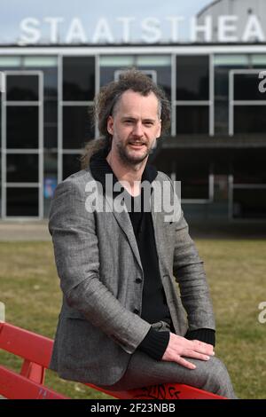 Kassel, Germany. 10th Mar, 2021. Florian Lutz, designated artistic director of the Staatstheater Kassel, sits on a bench in front of the theatre. Together with the designated heads of division, he presented the new concepts from the 2021-22 season. Credit: Uwe Zucchi/dpa/Alamy Live News Stock Photo