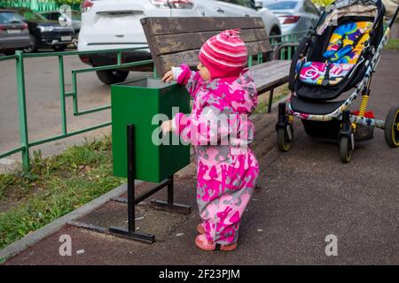 adorable child is throwing garbage in the trash Stock Photo