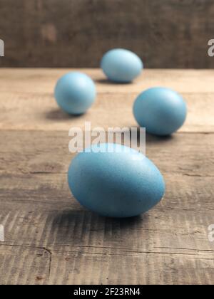 Naturally colored organic eggs on a rustic table with space for text, Easter background Stock Photo