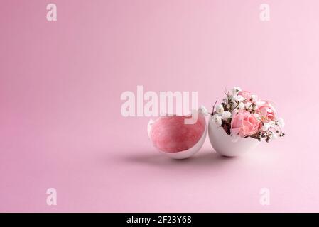 Pink and white flowers in eggshell on a pink background, close up. Easter card. Stock Photo