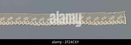 Strook kloskant met schuin geplaatste veervormige blaadjes.Strip natural colosside: Lille side. The repeating pattern consists on the center line from a row of diagonally placed veer-shaped leaves with a row of circular motifs connected below, which form openwork scoops. The motifs are connected by a fine grille, a tulet. The energy-saving fireworks is made in linen stroke, with thicker and shiny contour wires. The top is just finished. The scivels along the underside are finished with picots. Stock Photo