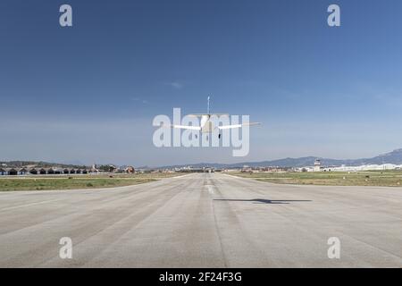 Light propeller aircraft landing on runway, close up symmetrical view Stock Photo