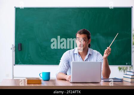 Young male teacher in tele-education concept in the classroom Stock Photo