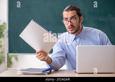 Young male teacher in the classroom in tele-education concept Stock Photo