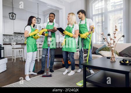 Multiracial team of cleaning service using digital tablet Stock Photo