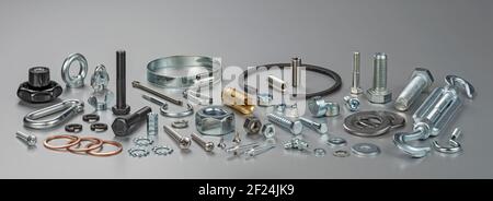 Different types of metal bolts, nuts, screws, hooks and washers. Fasteners and hardware tools on table. Stock Photo
