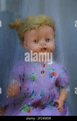 Dolls behind steamy window Stock Photo
