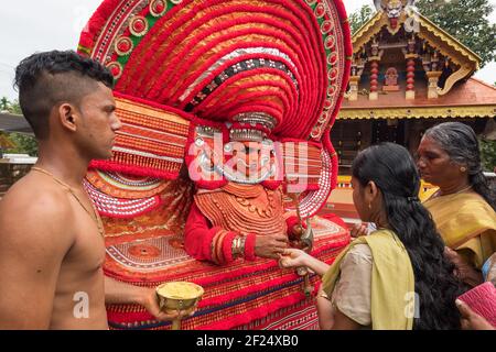 Kannur, India - December 2, 2019: Theyyam artist perform during temple festival in Kannur, Kerala, India. Theyyam is a popular ritual form of worship Stock Photo