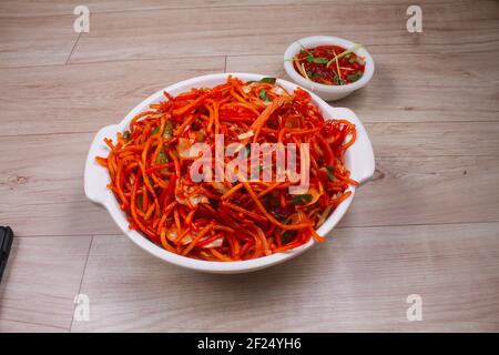 Schezwan Veg Noodles is a popular Indo-Chinese dish that is prepared with noodles, vegetables and show sauce and is served on a rustic wooden backgrou Stock Photo