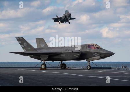 U.S. Marine F-35 stealth fighter test pilot Maj. Dylan Nicholas, and British Royal Navy Lt. Cmdr. Barry Pilkington, perform day envelope expansion test flights on the flight deck of the Italian Navy flagship aircraft carrier ITS Cavour during carrier qualifications in the Atlantic Ocean March 3, 2021, off the coast of Norfolk, Virginia. Stock Photo