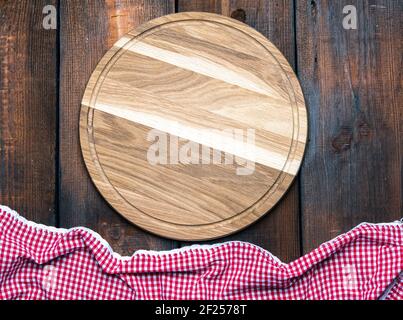 Empty round wooden cutting board and red napkin Stock Photo