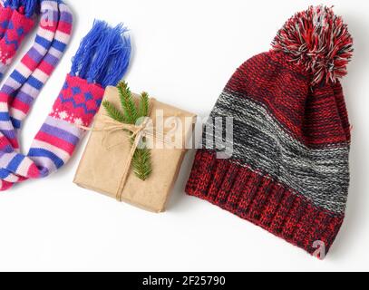 Winter hat,  gift box and multicolored knitted scarf on a white background, Stock Photo