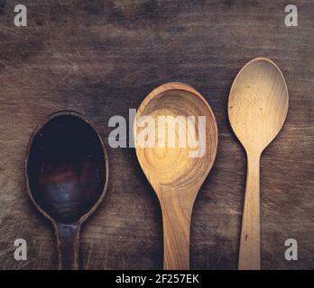 Empty brown wooden spoons on a gray wooden surface from old boards Stock Photo