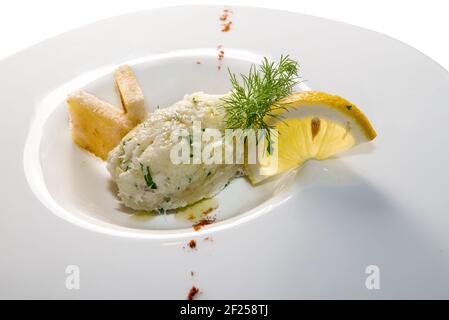 creamy cod, typical Venetian appetizer, called "baccalà mantecato" in a white dish with lemon slice and toasted bread Stock Photo