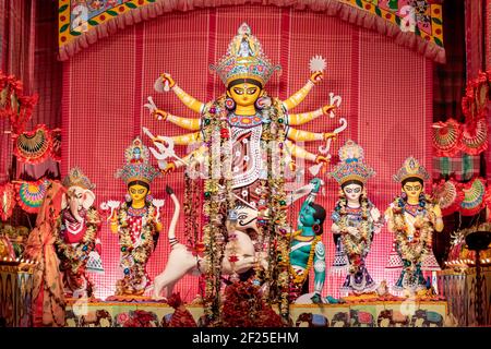 Goddess Durga idol at decorated Durga Puja pandal, shot at colored light, at Kolkata, West Bengal, India. Durga Puja is biggest religious festival of Stock Photo