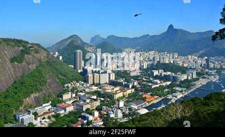 Landscape with a helicopter flying over Rio de Janeiro with panoramic view of the city on the background in Brazil. Stock Photo
