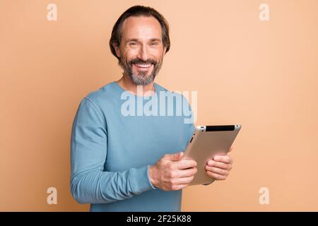 Photo portrait of businessman using tablet working on project smiling isolated on pastel beige color background Stock Photo