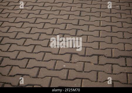 A close-up shot of the black cobbled stone road with small pebbles. Stock Photo