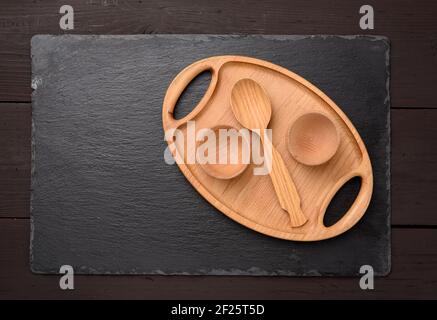 Empty oval brown wooden tray board on a black background Stock Photo