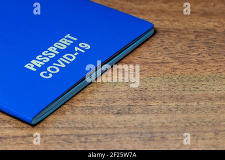 Blue passport with note COVID-19 on the desk. Travel and coronavirus concept Stock Photo