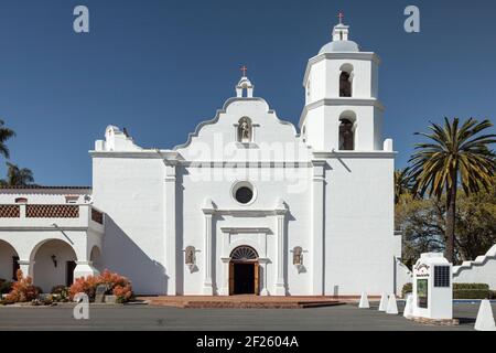 Oceanside, California  USA - March 5, 2021: Front-facing view of Mission San Luis Rey Church with bell tower, entrance door, statues in alcoves, monum Stock Photo