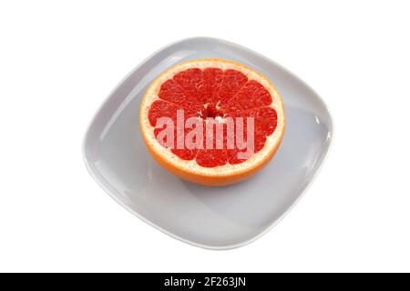 Ripe red grapefruit. The cut fruit on a blue plate Stock Photo