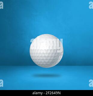 White golf ball on a blue studio background Stock Photo