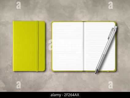Lime green closed and open lined notebooks with a pen on concrete background Stock Photo