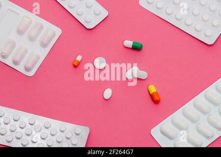 Assorted medicinal pills with blister packs placed on a pink background Stock Photo