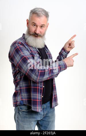 Studio portrait mature man dressed in casual clothes points aside, I choose this, white backdrop Stock Photo
