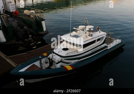 Moored Guardia Civil boats on a calm morning in the Maliano Dock with a green bridge Santander Cantabria Spain Winter Stock Photo