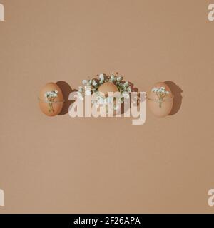 2021 Easter layout with  domestic natural eggs with  spring flowers over pastel background. Minimal flat lay holiday concept. Stock Photo